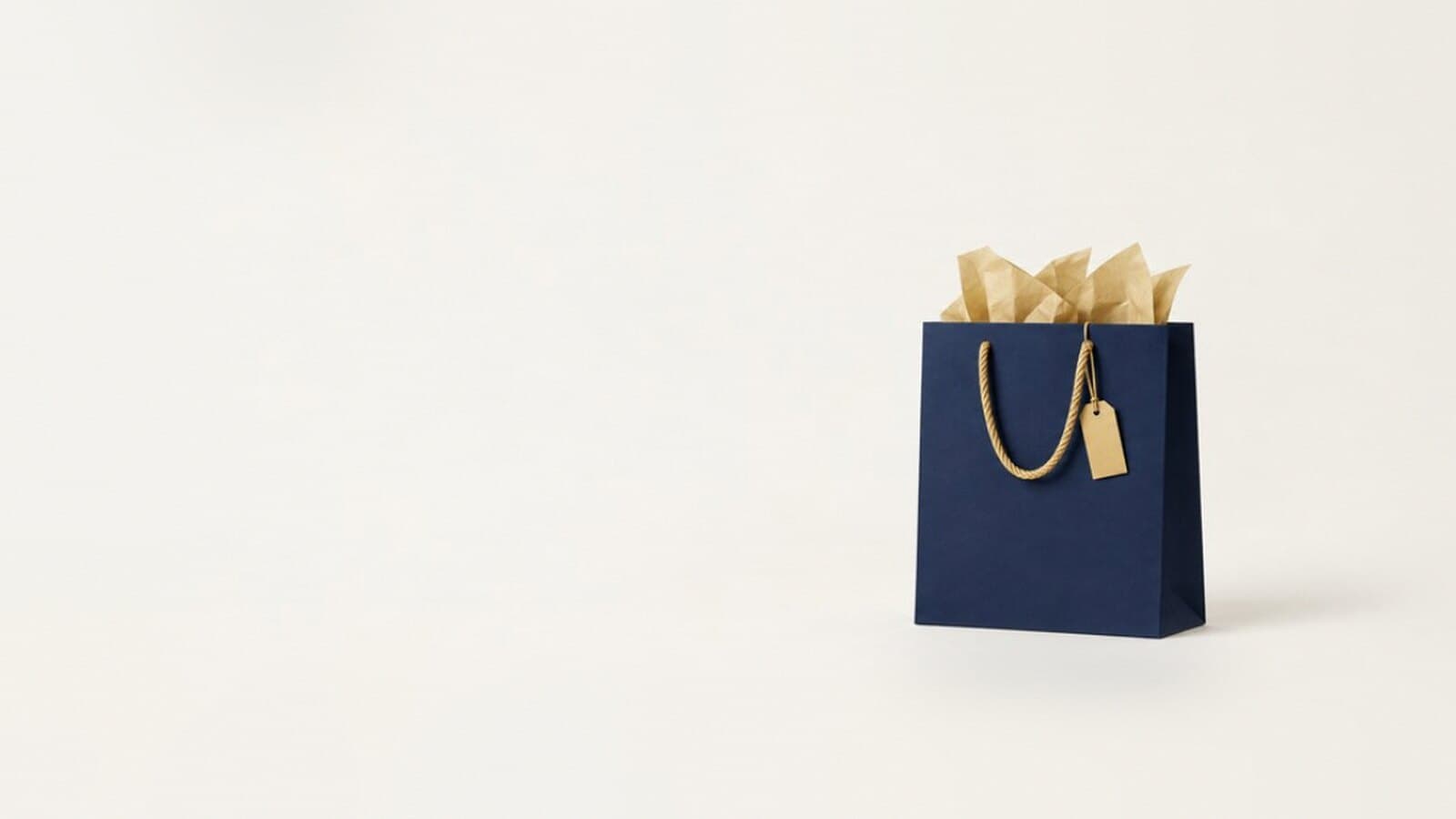 Una borsa shopping blu navy con carta velina dorata e un cartellino: l'immagine del playbook per il Black Friday.