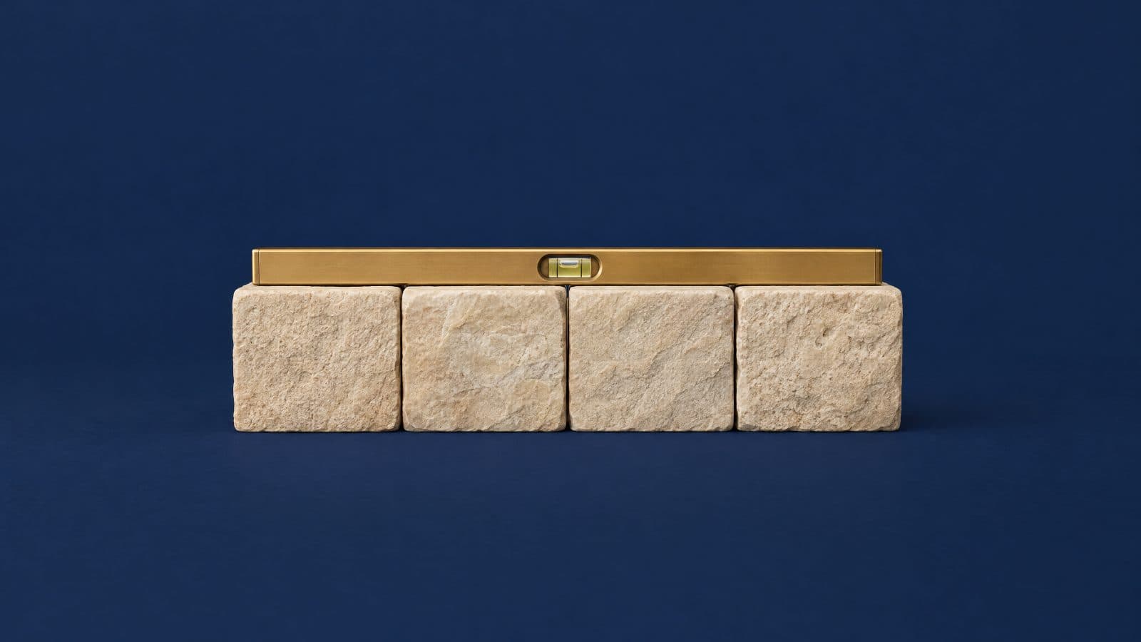 Four stone foundation blocks with a spirit level on top: get the base right first.